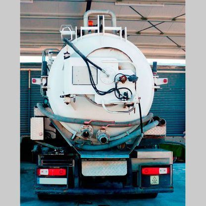 Un camión de vacío blanco está estacionado en un garaje.