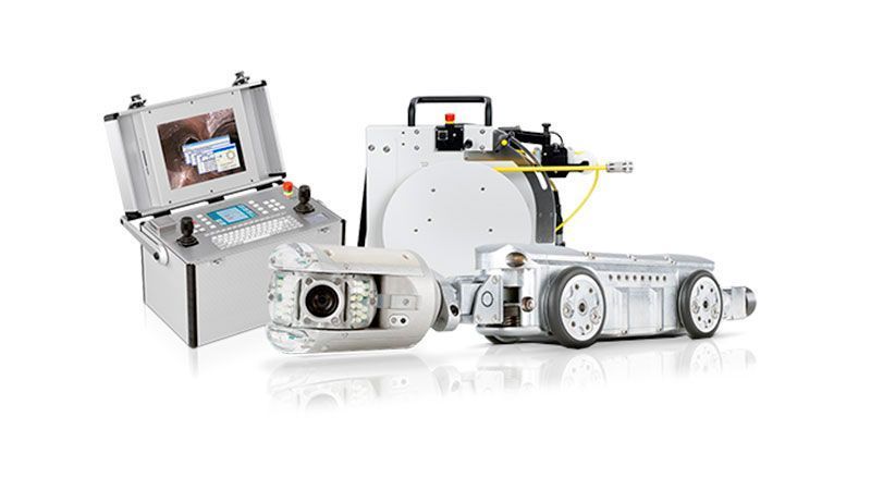 Un grupo de robots están sentados uno al lado del otro sobre una superficie blanca.