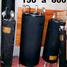 Tres cilindros negros están uno al lado del otro sobre una mesa.