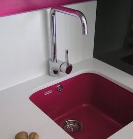 Un fregadero de cocina rosa con grifo cromado.