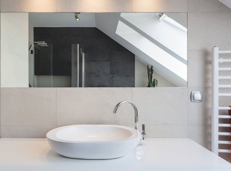 Un baño con lavabo y un espejo grande.