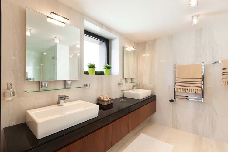 Un baño con dos lavabos, un espejo y una ventana.