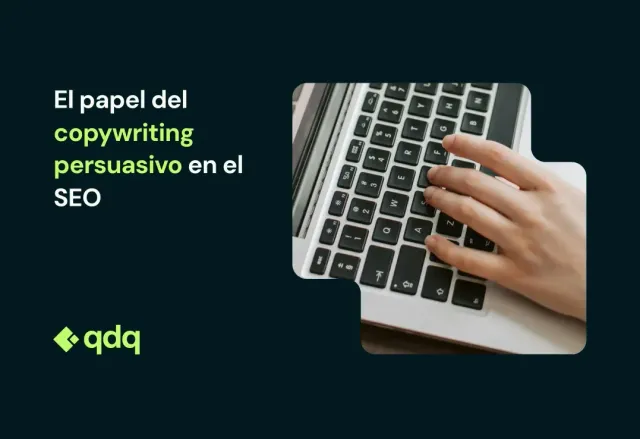 Person's hand typing on a laptop keyboard. The laptop is open on a wooden surface.