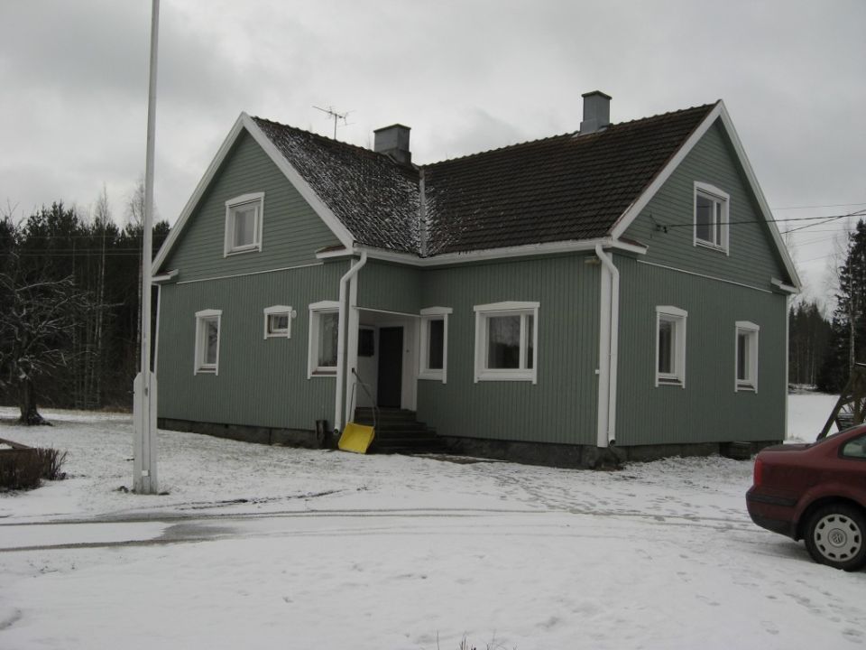 Pitkän talon ikkkunoilla on punaiset raamit.