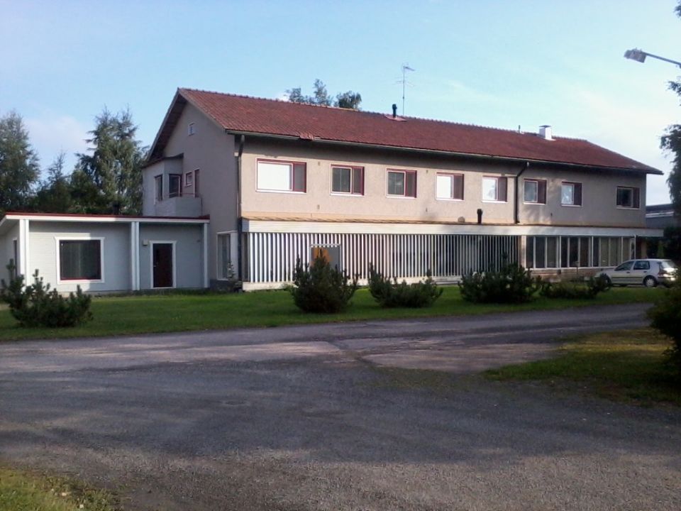 Pitkän talon ikkkunoilla on punaiset raamit.