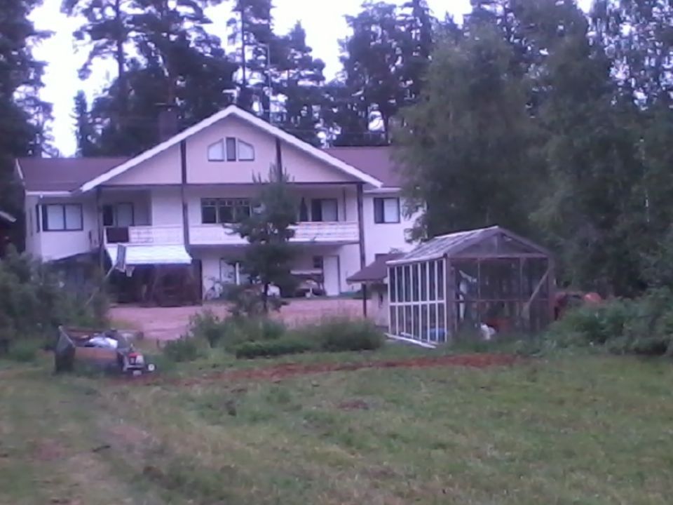 Pitkän talon ikkkunoilla on punaiset raamit.