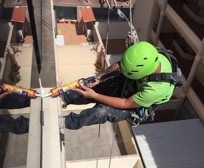 Un hombre que lleva un casco verde está trabajando en un edificio.