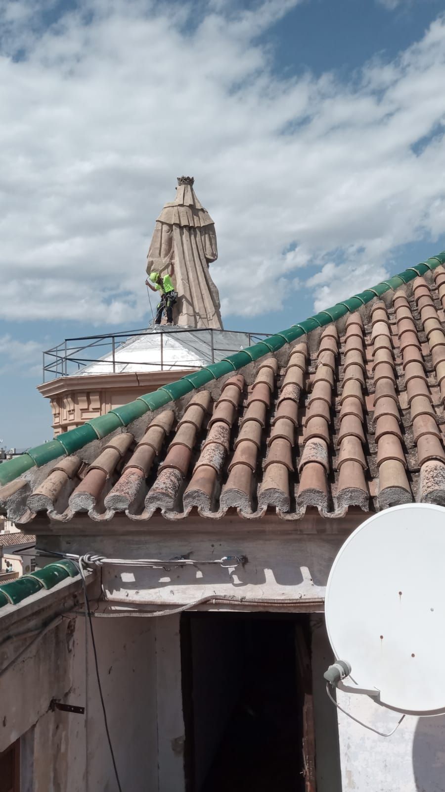 Un techo con una antena parabólica y una estatua encima.