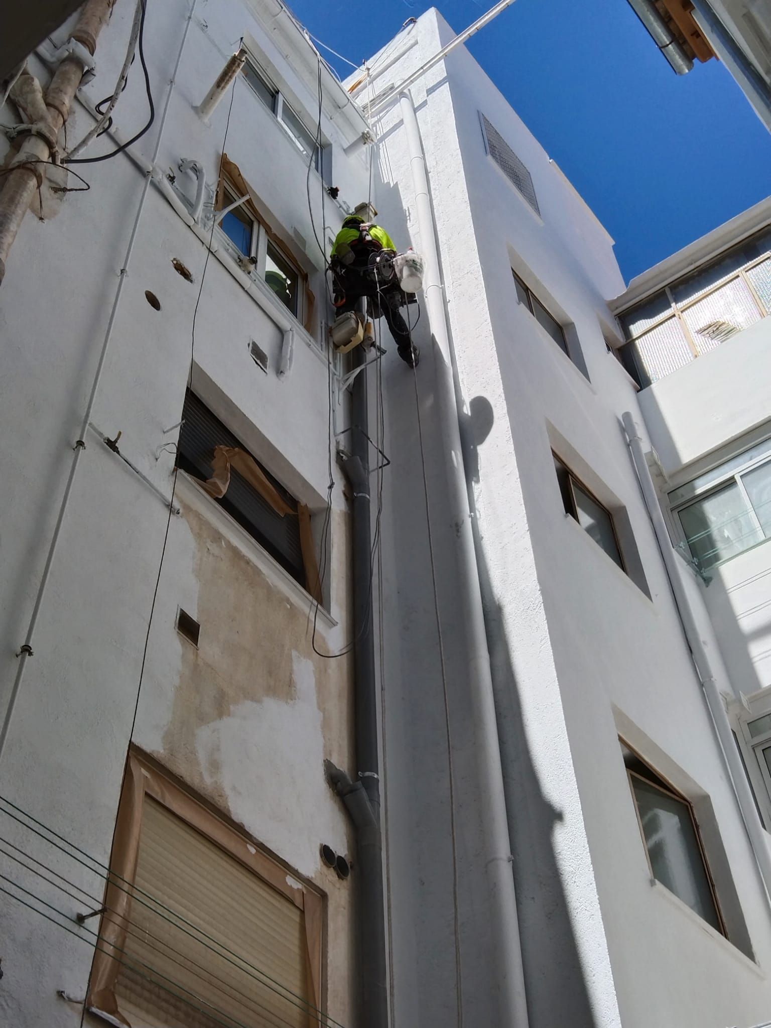 Un hombre está subiendo por el costado de un edificio.