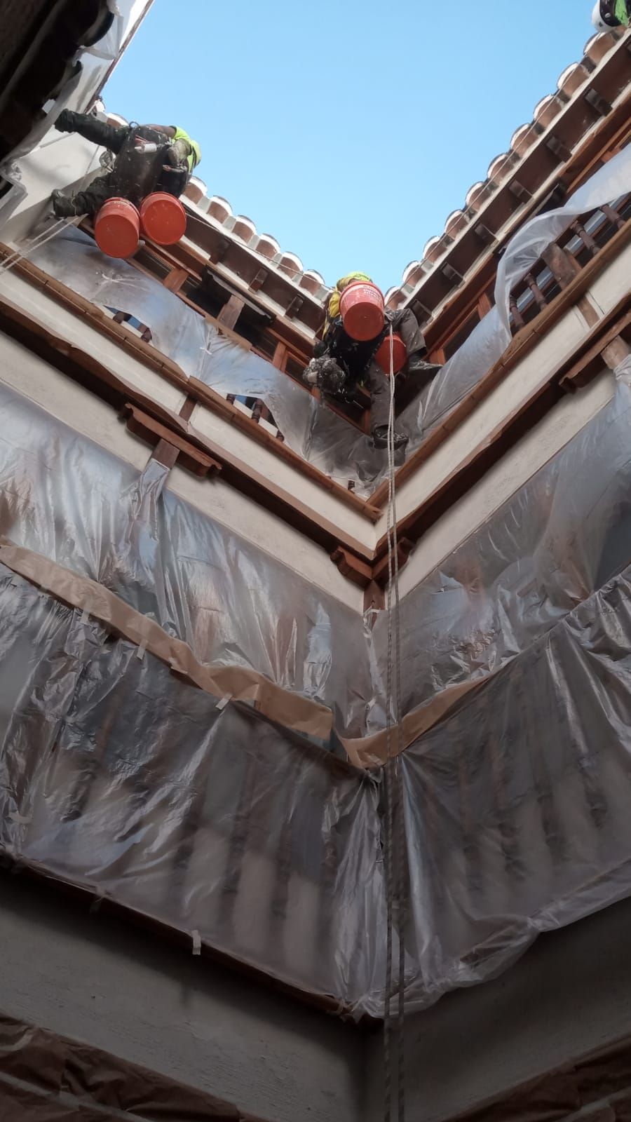 Un grupo de personas está trabajando en el tejado de un edificio.