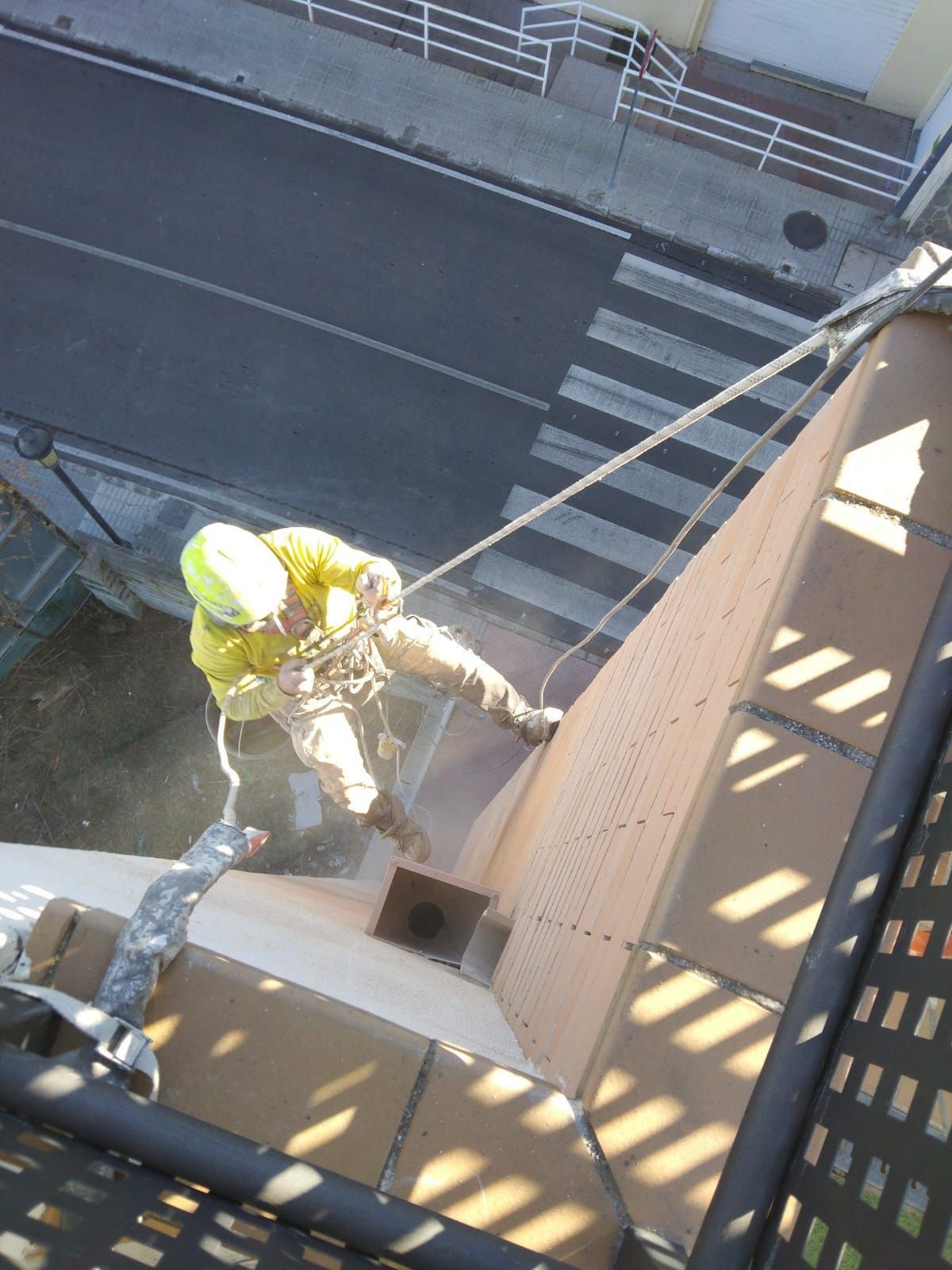 Un hombre está subiendo un edificio con una cuerda.