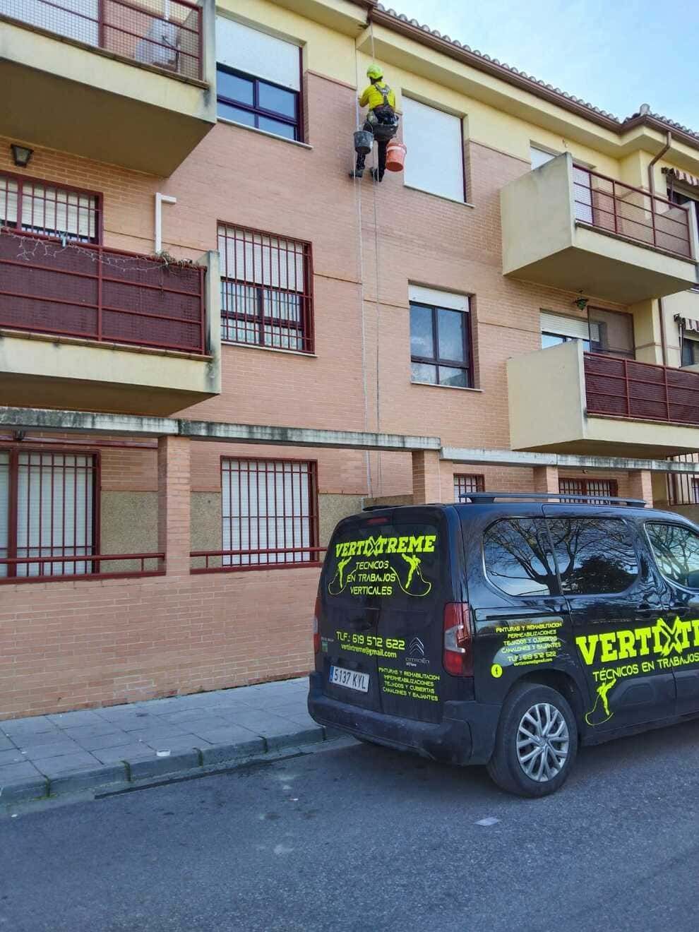 Una furgoneta está aparcada delante de un edificio de ladrillos.