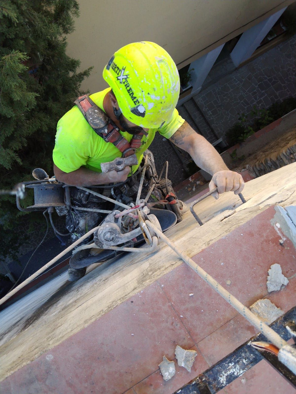 Un hombre que lleva un casco amarillo está trabajando en un tejado.