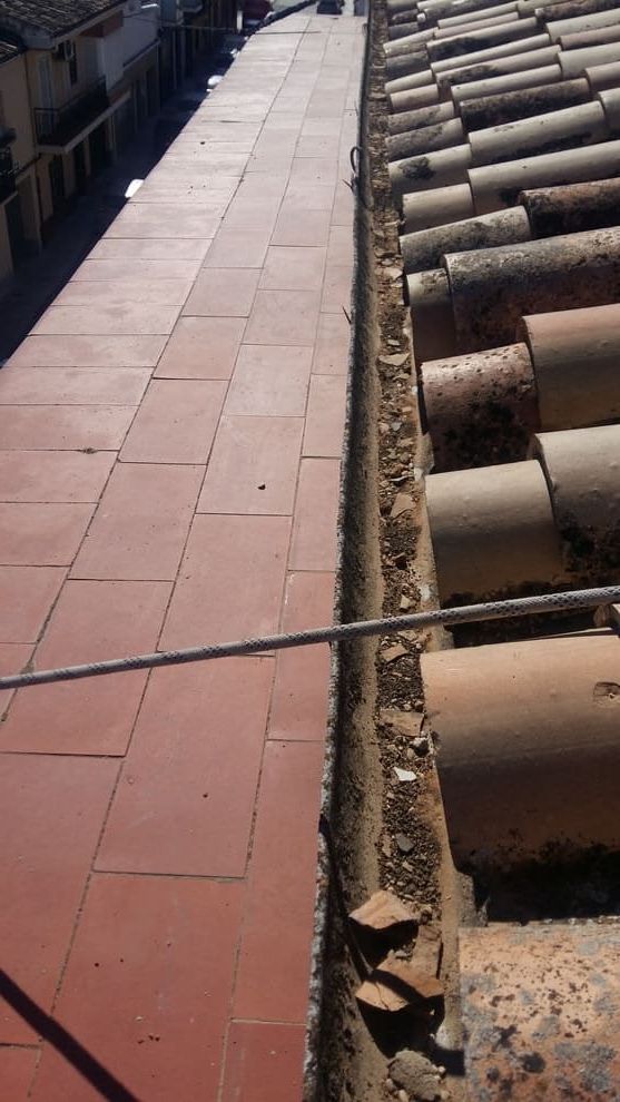 Un desagüe en el costado de un edificio al lado de un techo.