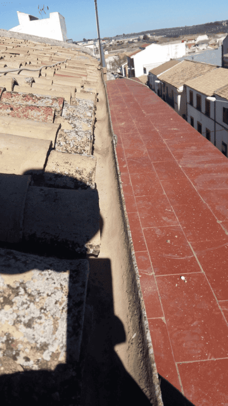 Un desagüe en el costado de un edificio con una sombra sobre él.