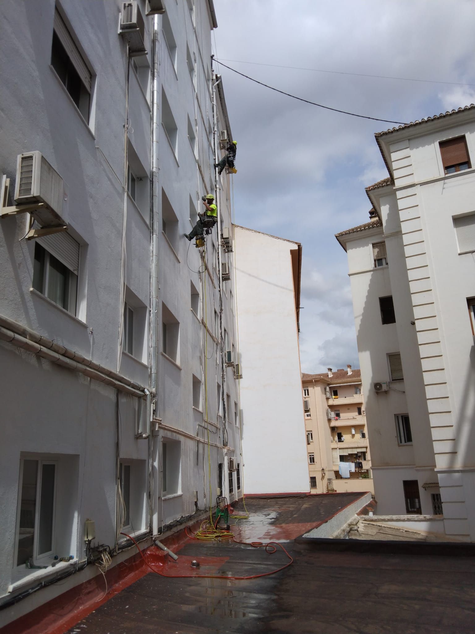 Un callejón estrecho entre dos edificios altos y blancos.