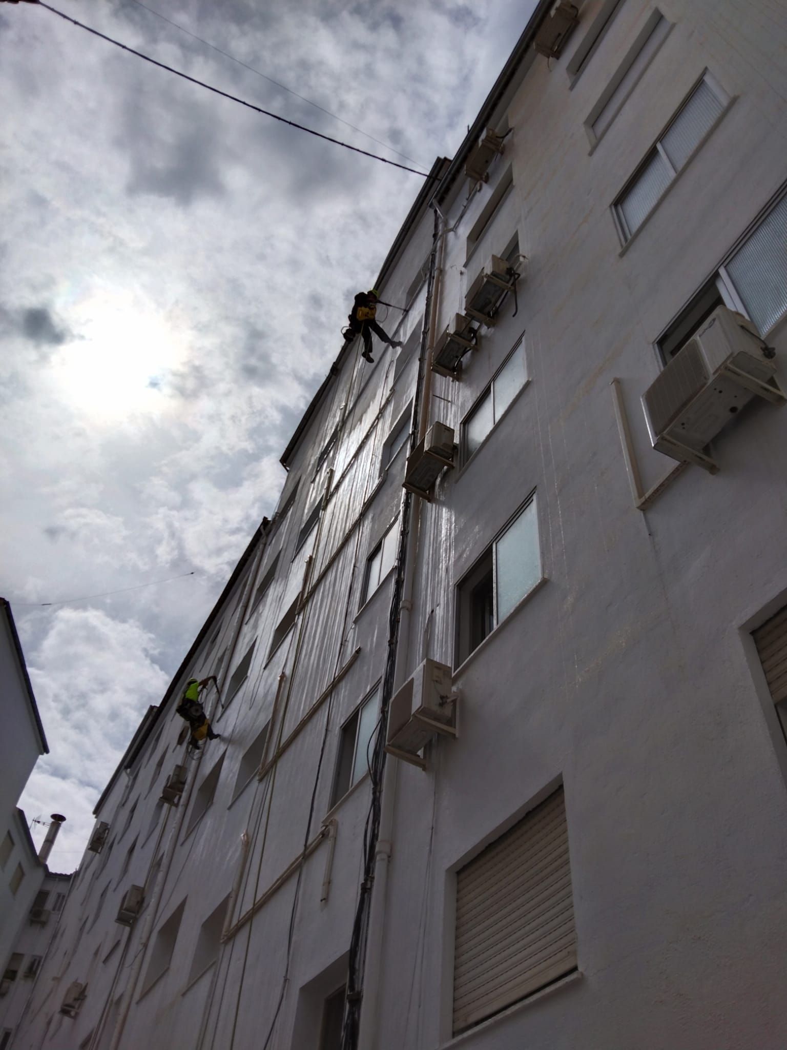 Un hombre está subiendo por el costado de un edificio.
