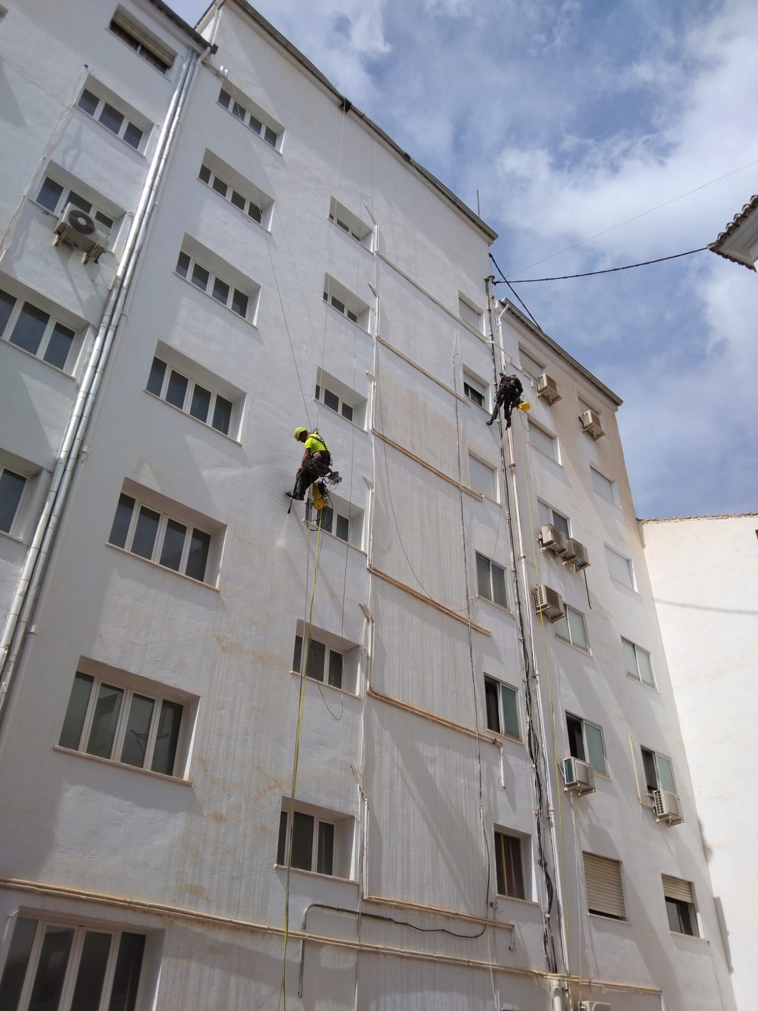 Un hombre está subiendo por el costado de un edificio alto.