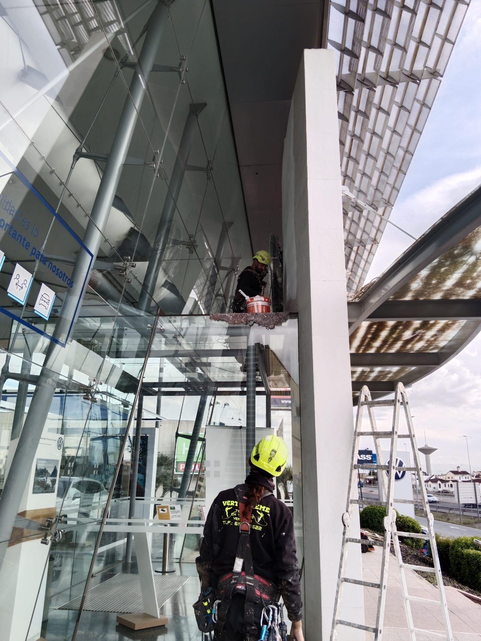 Un hombre está parado en una escalera frente a un edificio.