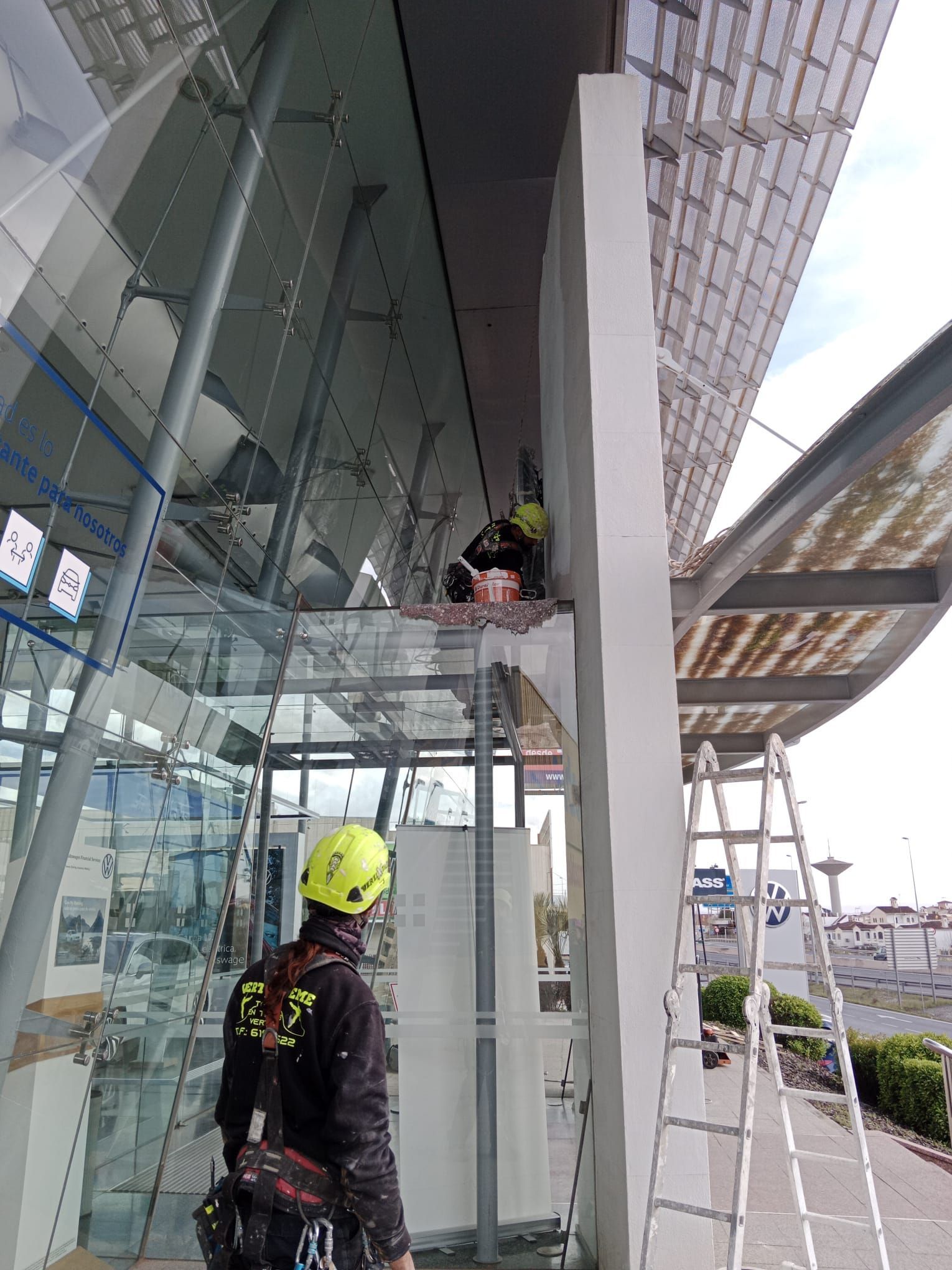 Un hombre está parado en una escalera frente a un edificio.