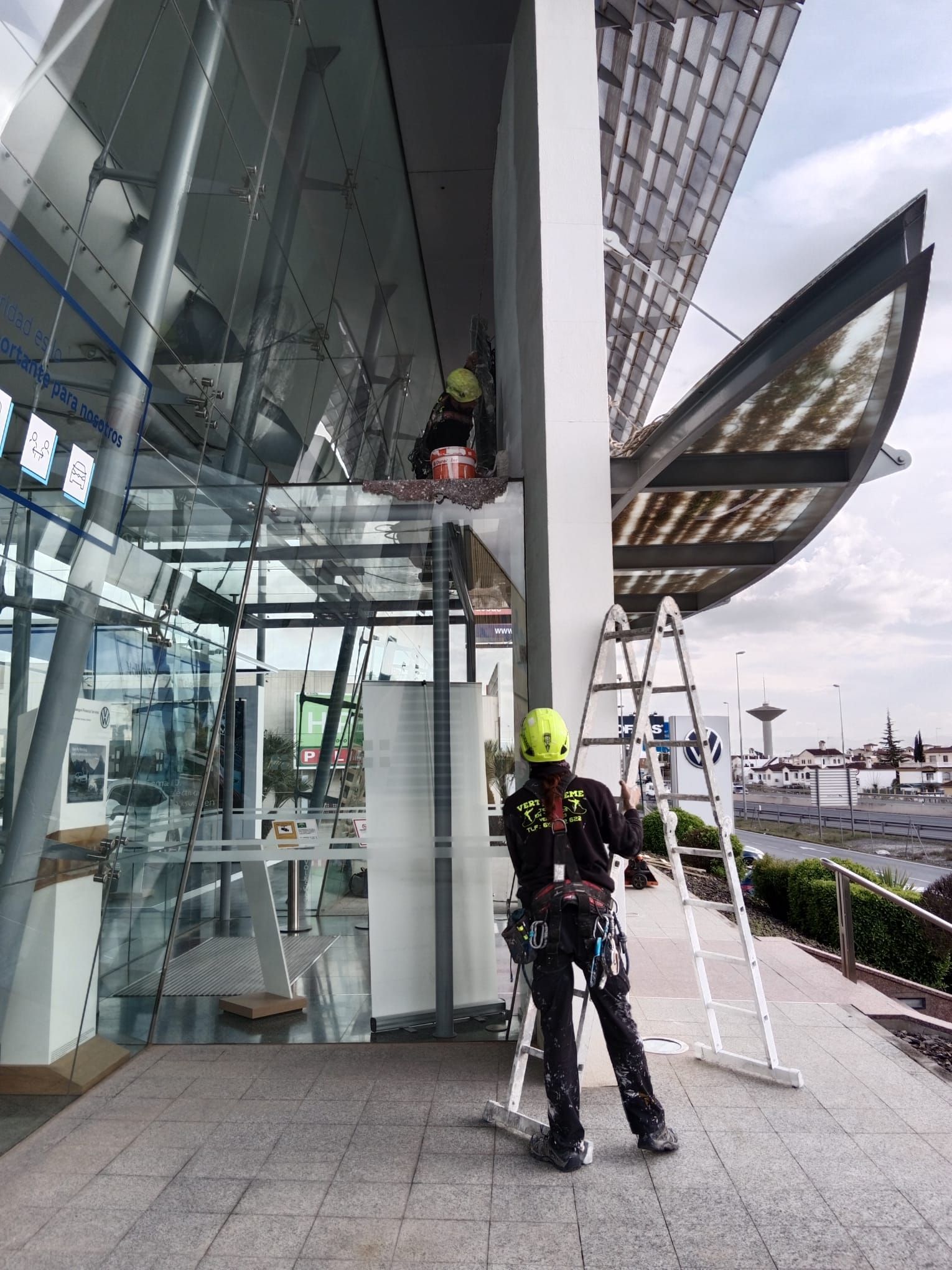 Un hombre está parado en una escalera frente a un edificio.