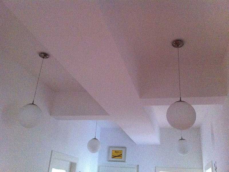 Ein Flur mit drei Pendelleuchten, die von der Decke hängen