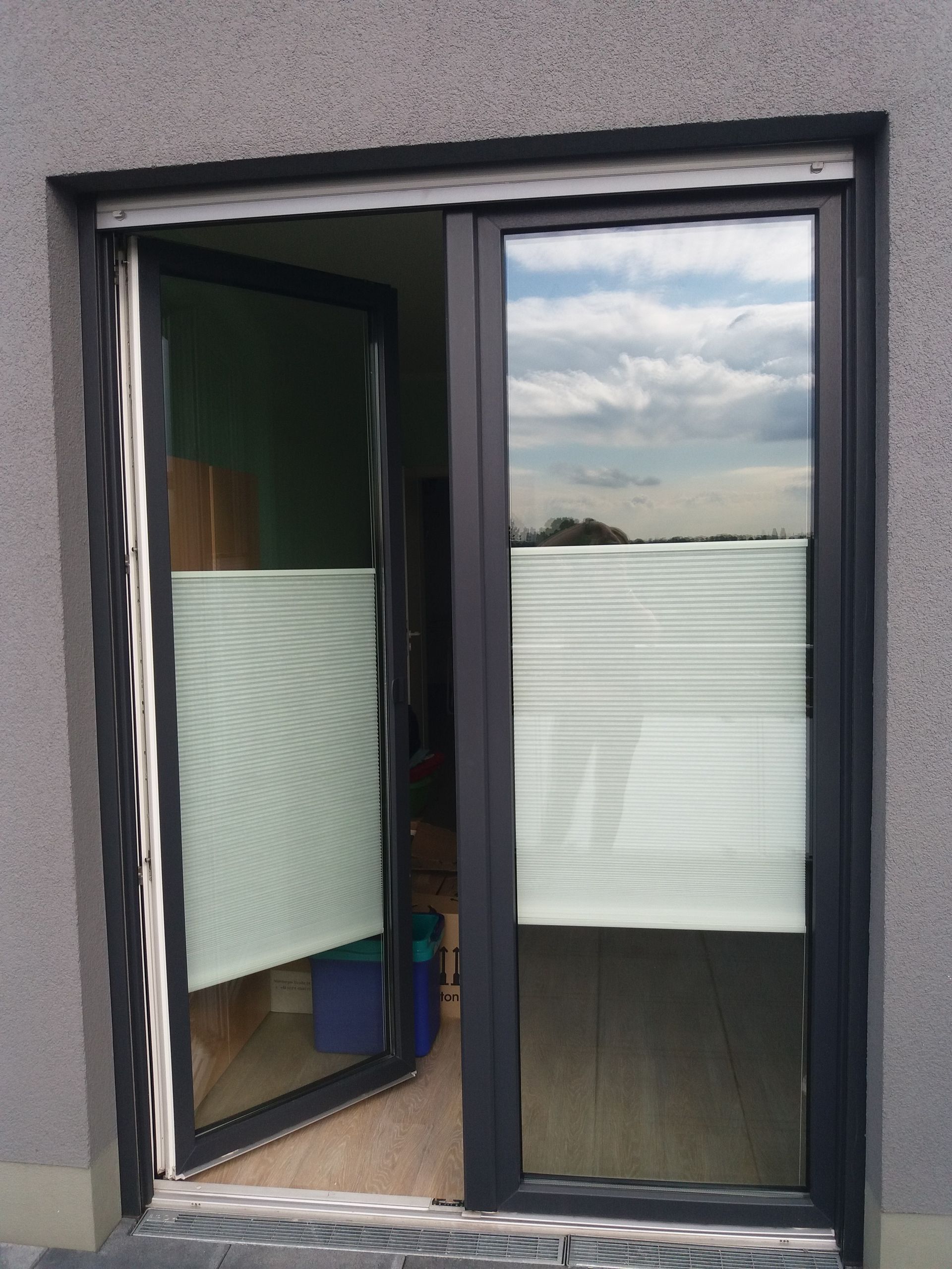 Eine Glasschiebetür mit Jalousien