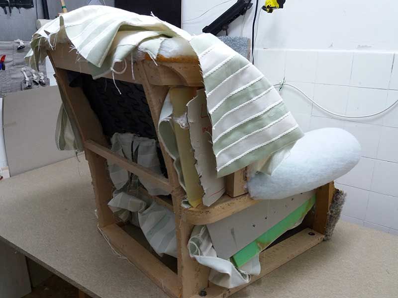 Auf einem Holztisch steht ein Stuhl, auf dem ein Stück Stoff liegt.