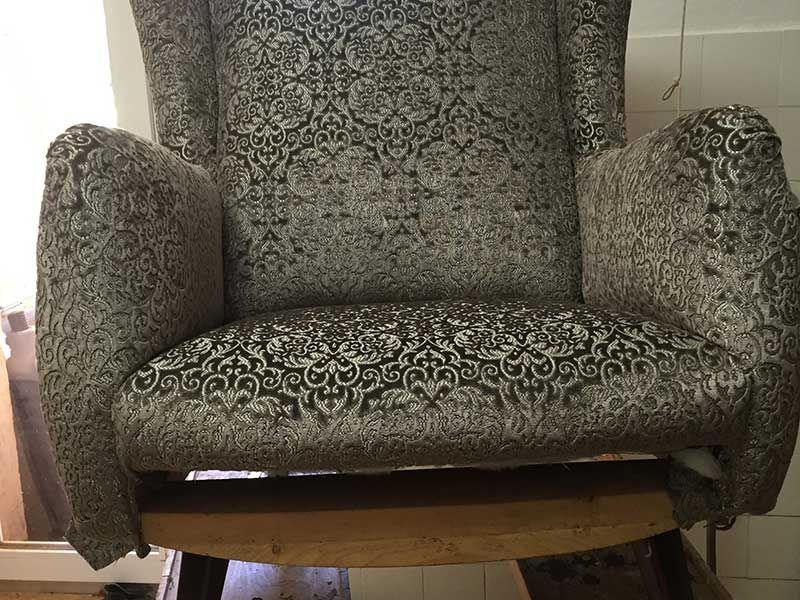 Auf einem Holztisch steht ein Stuhl mit einem Muster.