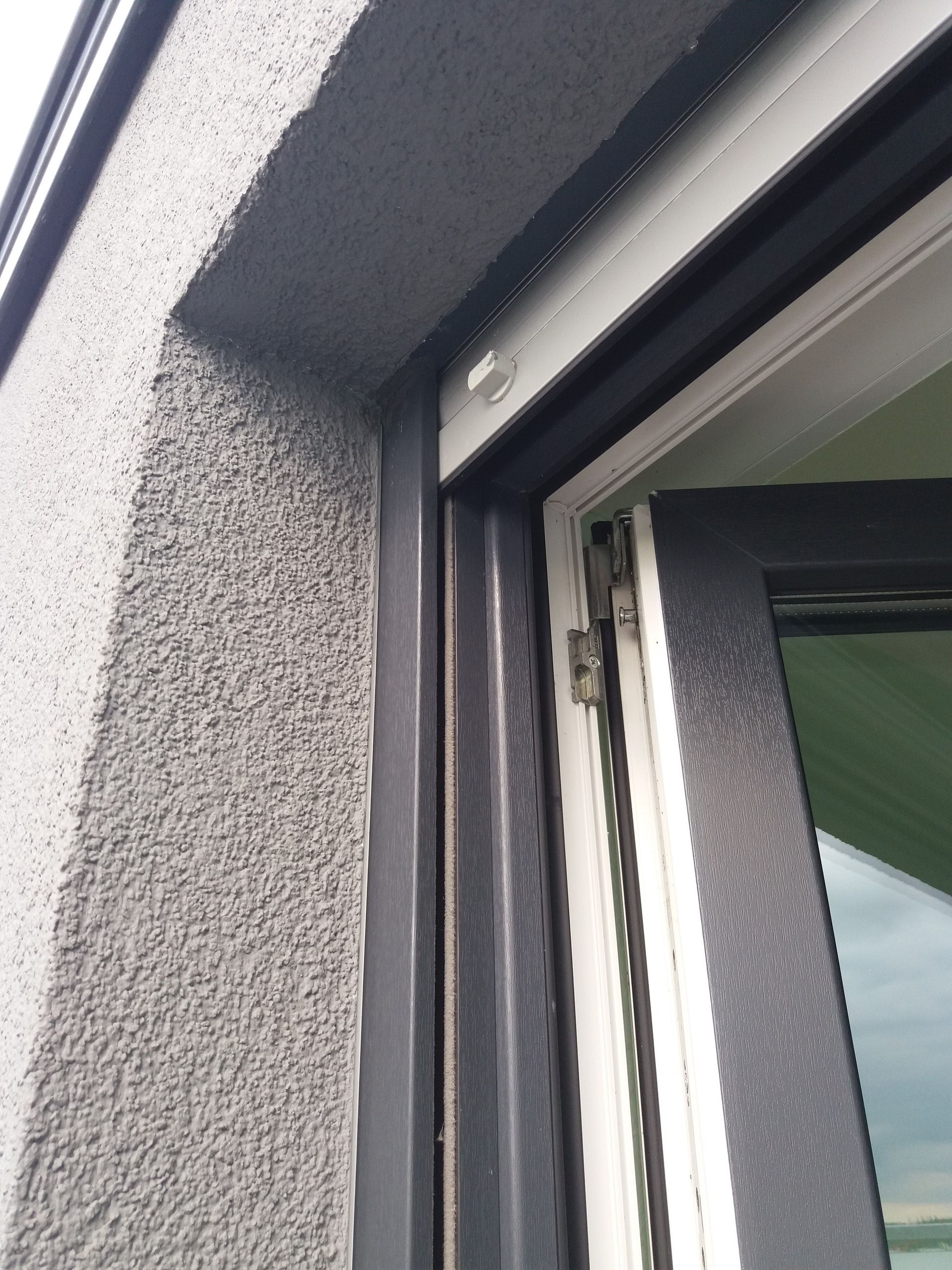 Eine Nahaufnahme eines Fensters an einer grauen Wand