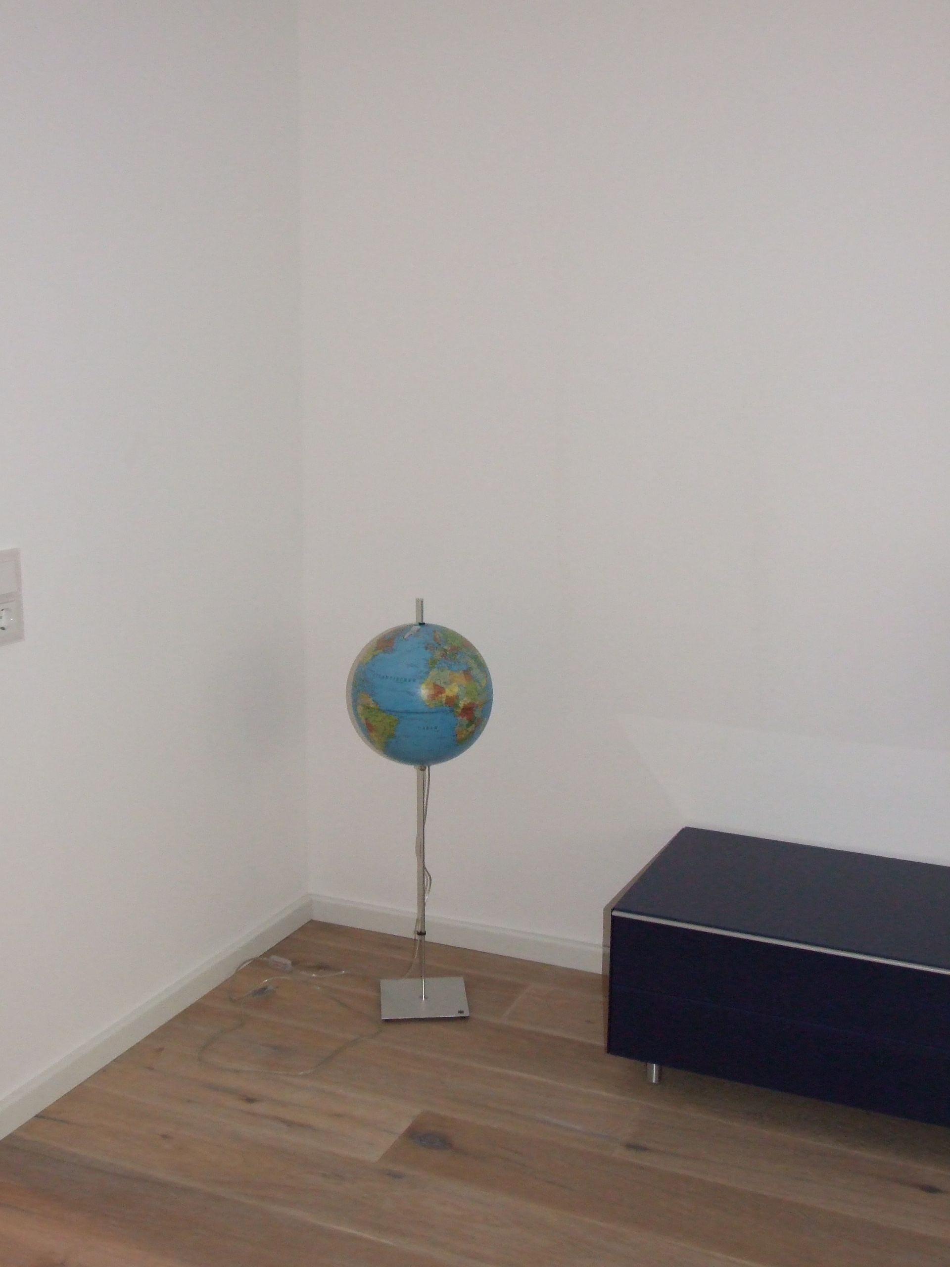 Ein Globus auf einem Ständer in einer Zimmerecke