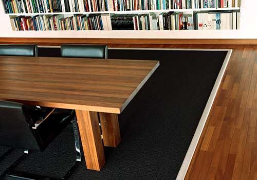 Ein Holztisch und Stühle vor einem Bücherregal voller Bücher