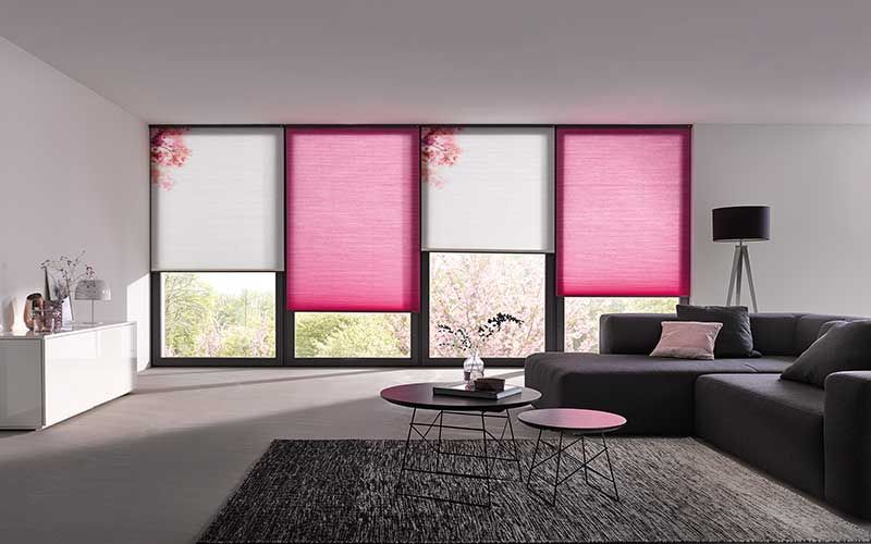 Ein Wohnzimmer mit einer Couch, Couchtischen und rosa Jalousien.