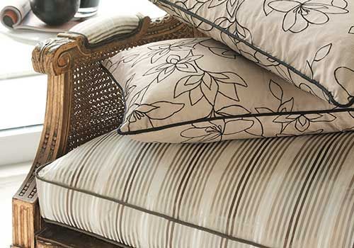 Zwei Kissen liegen übereinander auf einem Stuhl