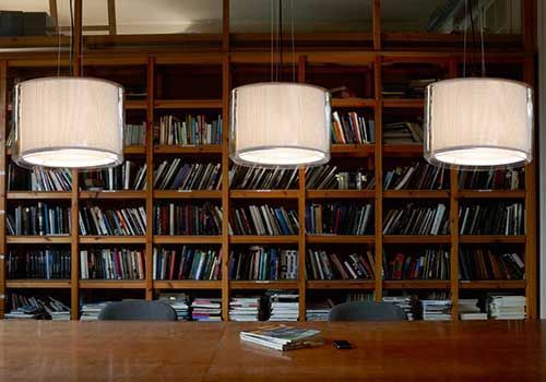 Eine Bibliothek mit einem Tisch und Stühlen vor einer Wand aus Bücherregalen.