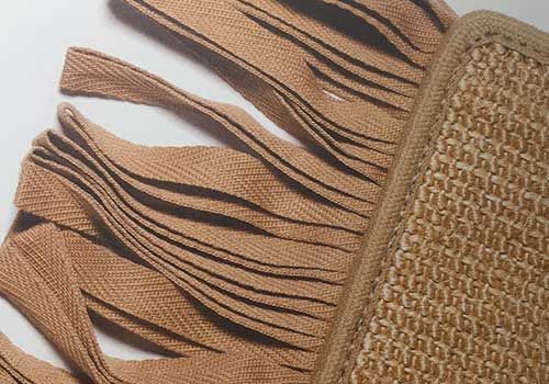 Eine Nahaufnahme von einem Stück Stoff mit Fransen