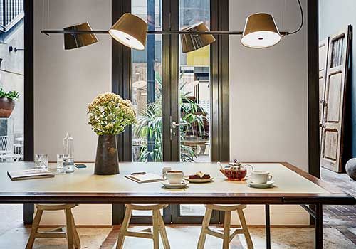 Ein Esstisch mit Hockern und einer Vase mit Blumen darauf.