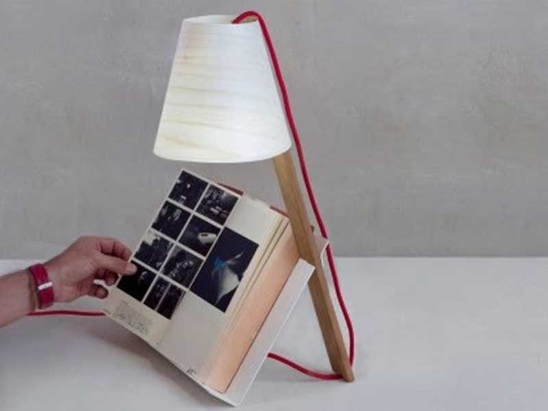 Eine Person hält ein Buch vor einer Lampe