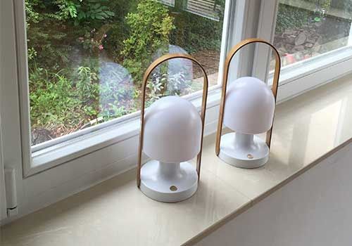 Zwei Lampen stehen auf einem Fensterbrett neben einem Fenster.