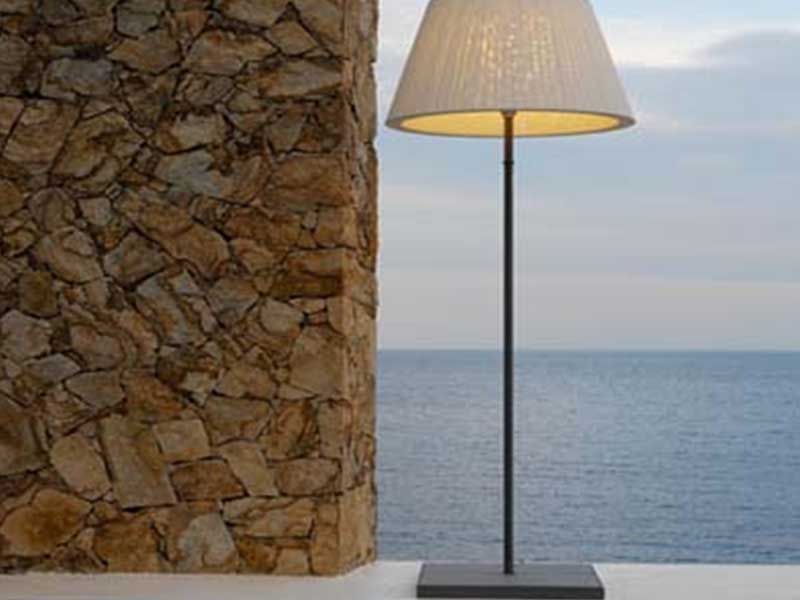 Eine Lampe steht vor einer Steinmauer mit Blick auf den Ozean.