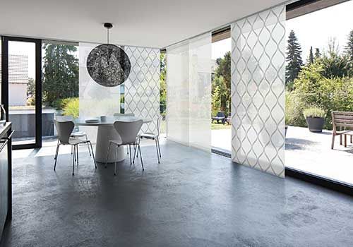 Ein Esszimmer mit Tisch und Stühlen und einem großen Fenster.