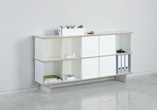 Ein weißes Regal mit Büchern und Ordnern darauf in einem Zimmer.