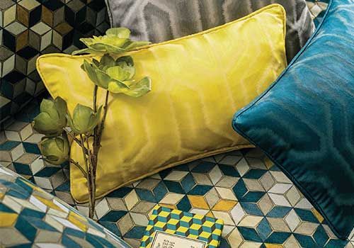 Auf einem Sofa liegt ein gelbes Kissen neben einem blauen Kissen.