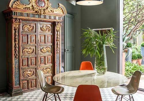 Ein Esszimmer mit einem Tisch und Stühlen und einer Vase mit Pflanzen.