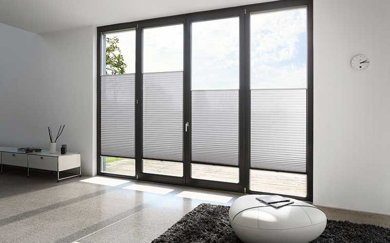 Ein Wohnzimmer mit großem Fenster und Teppich.