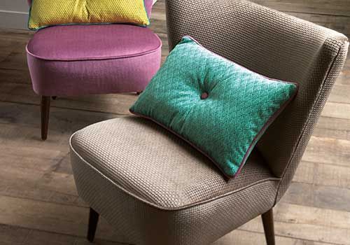 Zwei Stühle mit Kissen stehen auf einem Holzboden.