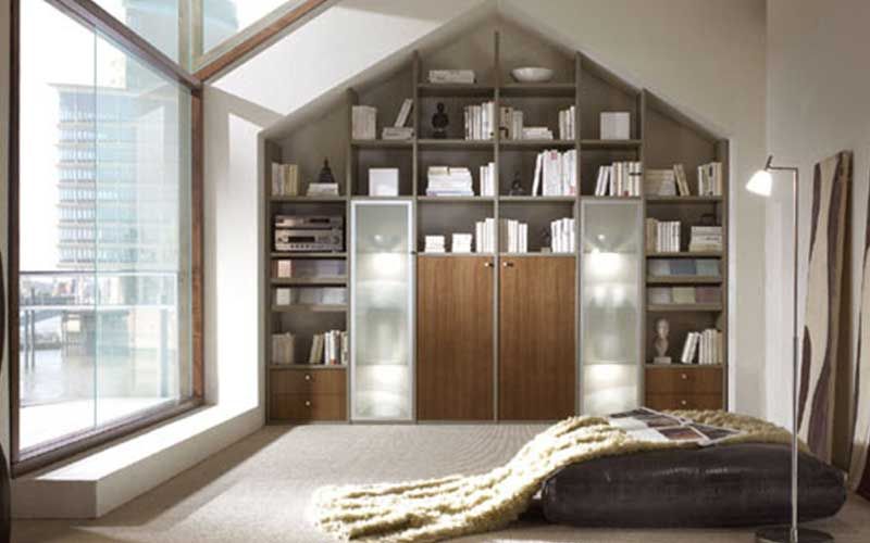 Ein Zimmer mit vielen Bücherregalen und einem Bett