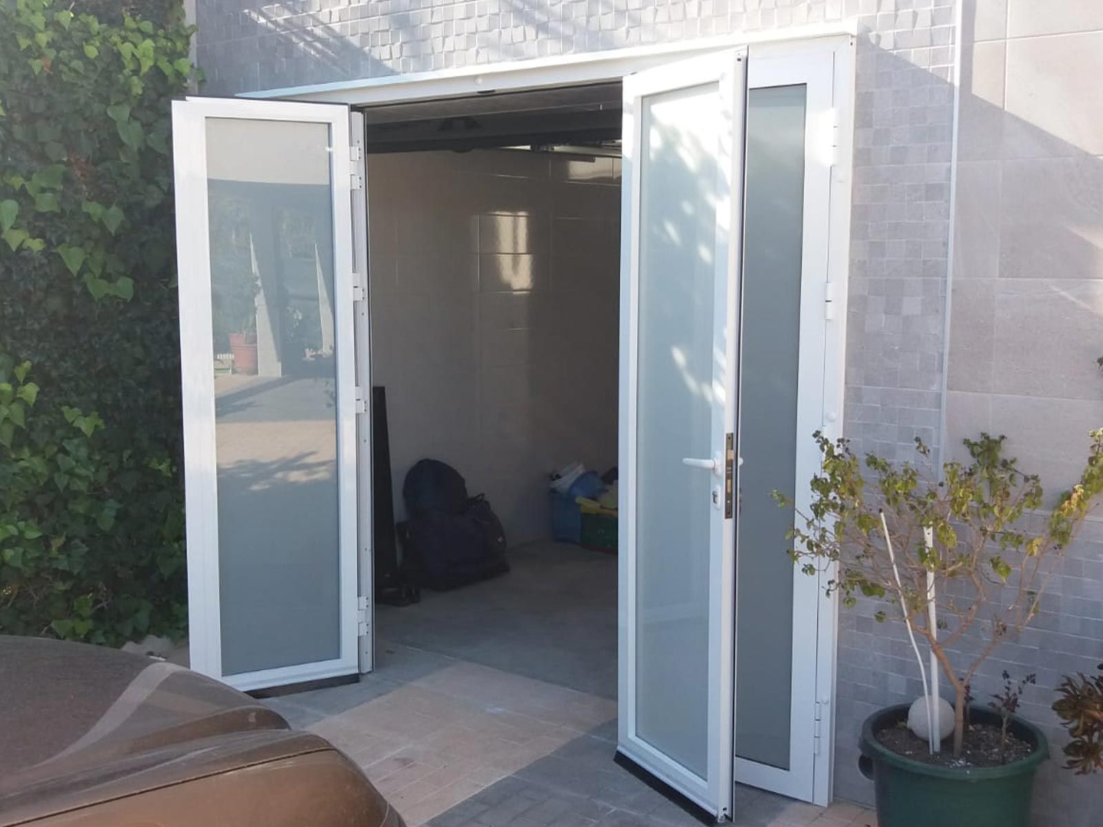 Una puerta blanca con vidrio esmerilado se abre a una habitación.