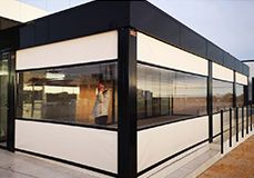 Un edificio con muchas ventanas y una persona parada frente a él.
