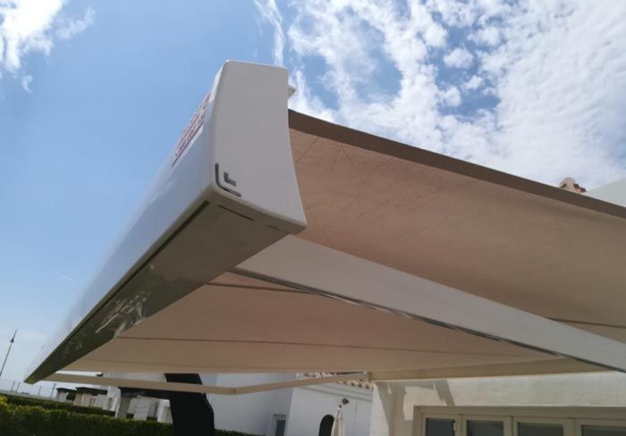 Un toldo blanco está sentado encima de un edificio blanco.